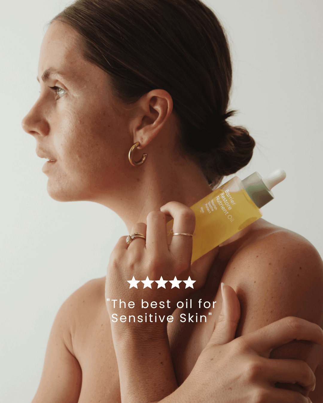 Barrier Restore Nutrient Oil being held by a woman with a 5 star review in the foreground