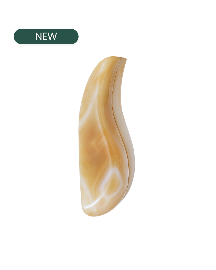 Agate gua sha for face golden hour against a white background