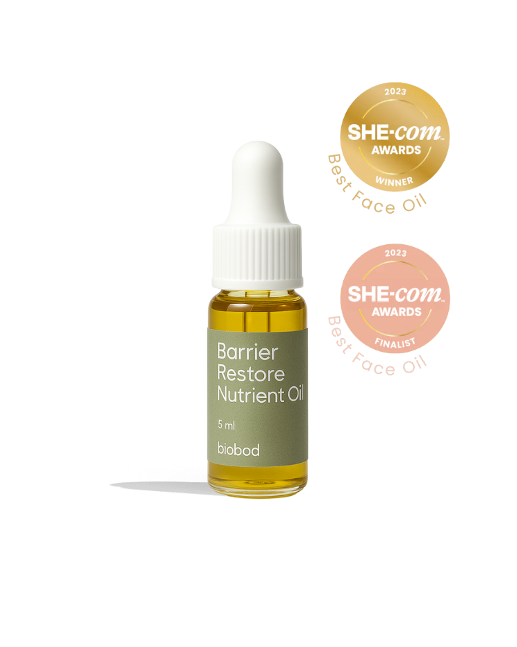A sample bottle of Barrier Restore Nutrient Oil by biobod, award-winning product with a she.com award of excellence in 2021, displayed on a green background.
